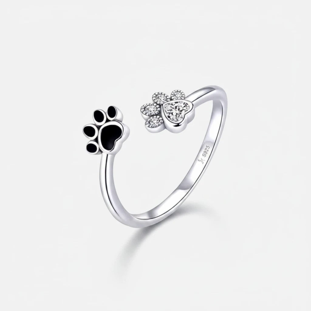 Anel ajustável Arrabida Atelier em prata com pata de animal, esmalte preto e zircões brilhantes em forma de coração.