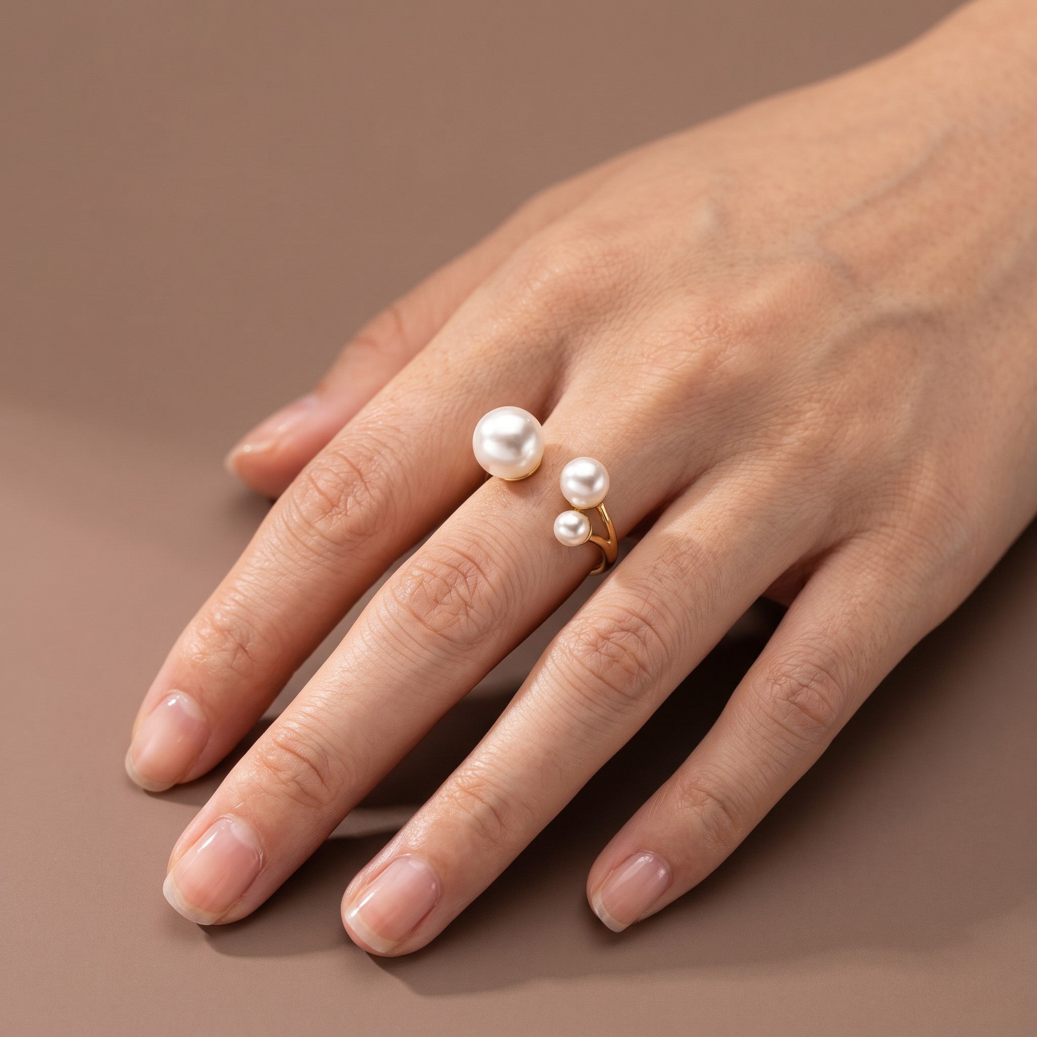 Anel Elegante Trio da Arrabida Atelier em ouro com três pérolas brancas de tamanhos diferentes no dedo